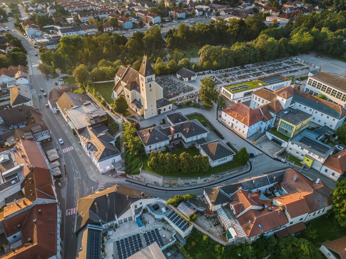 "Die 'grüne Lunge' mitten im Ort": Das Zentrum Böheimkirchens aus der Vogelperspektive. Im Zentrum steht die Kirche, rundherum sind Wohnhäuser und viele Grünflächen zu sehen.